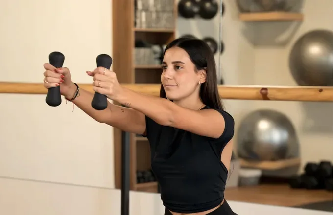 Trabajo de fuerza con mancuernas en clase de HIIT en Naü Studio