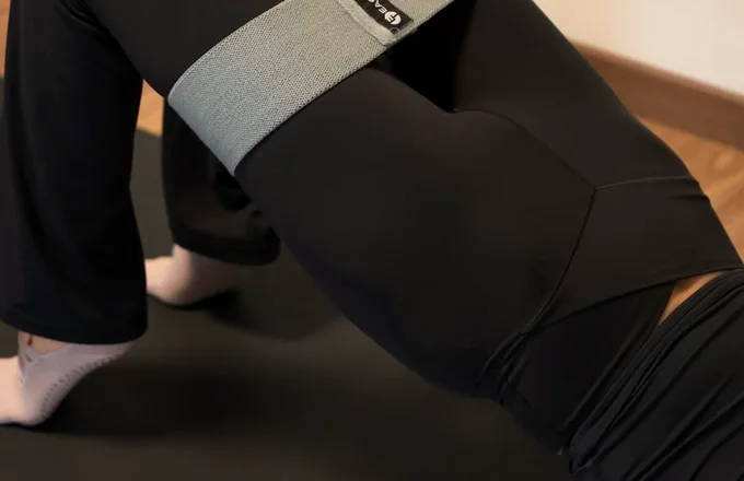 Ejercicio de puente con banda en clase de Pilates Mat en Naü Studio