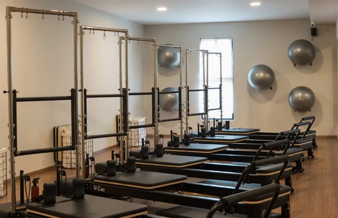 Salón de Naü Studio con torres de pilates sobre los reformers